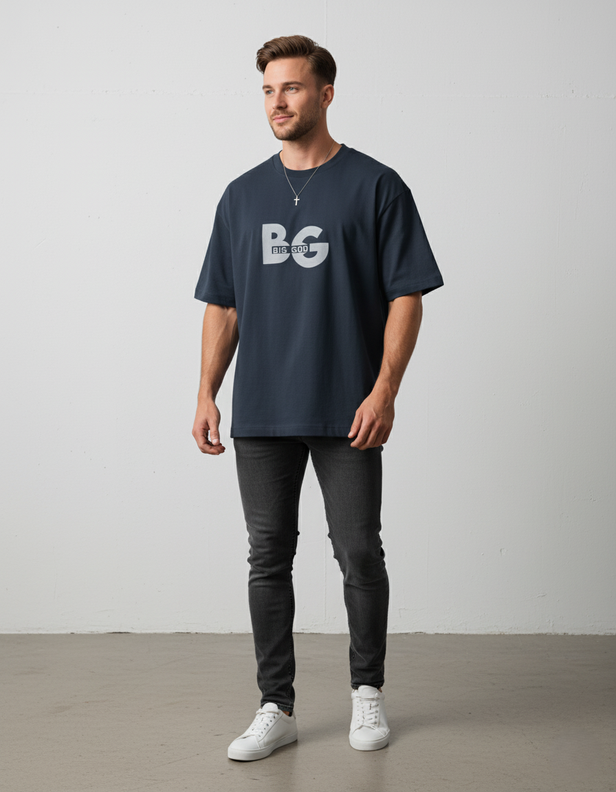 Man wearing a navy blue t-shirt with a logo, dark jeans, and white sneakers on a plain background