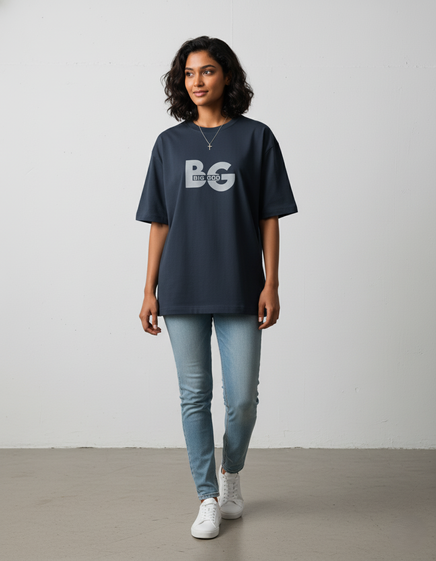 Person wearing a navyblue oversized t-shirt with 'BC' logo, light blue jeans, and white sneakers on a plain background
